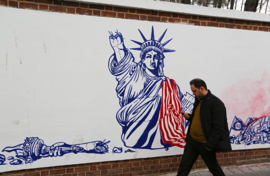 Egy iráni járókelő nézi a mobilját a teheráni USA nagykövetség falára rajzolt graffitti előtt sétálva 2020. január 4-én #moszkvater