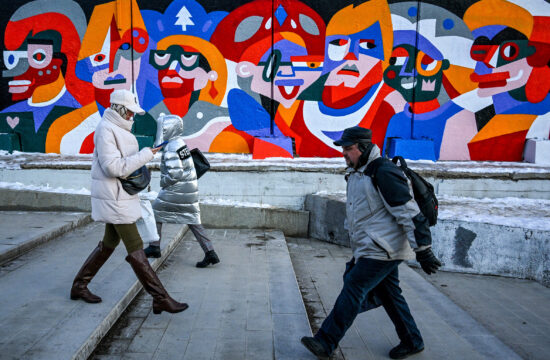 Járókelők mennek el Olya Iney orosz garffitiművész alkotása előtt a moszkvai Kurszkij pályaudvar kerítése előtt 2022. december 10-én #moszkvater
